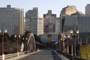 Foto do viaduto Santa Tereza, em Belo Horizonte. Uma arte em um prédio alto aparece ao fundo.